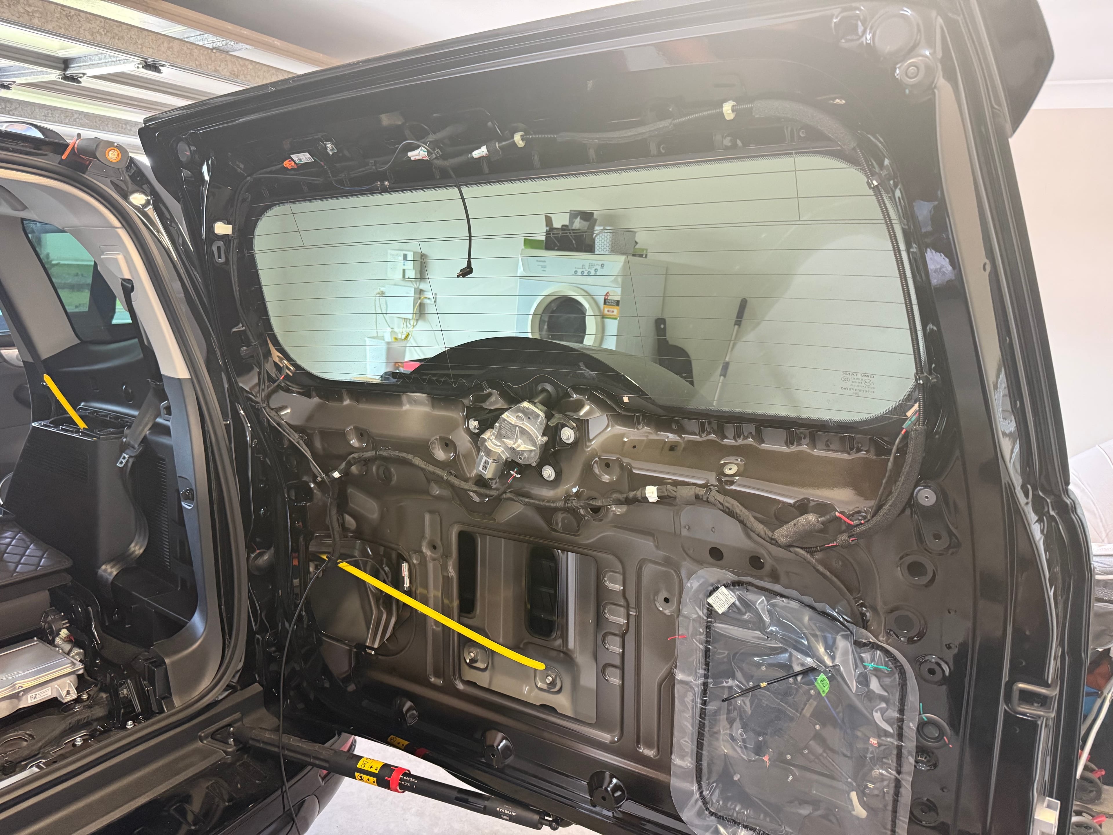Mobile technician fitting car audio equipment in a residential driveway