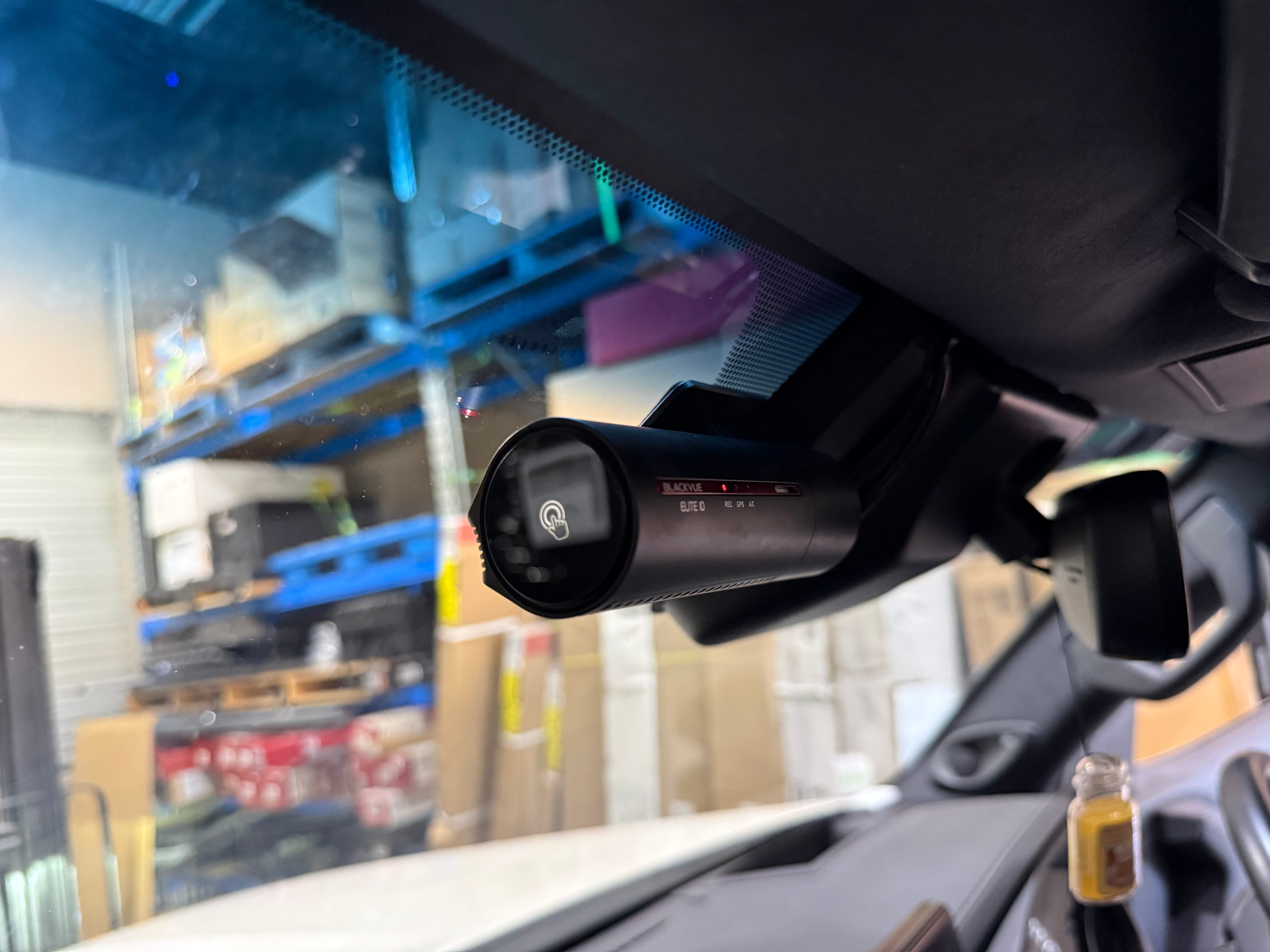 Technician fitting a dash camera in a vehicle